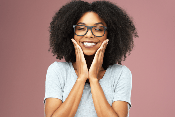 smiling, peaceful girl with hands to face