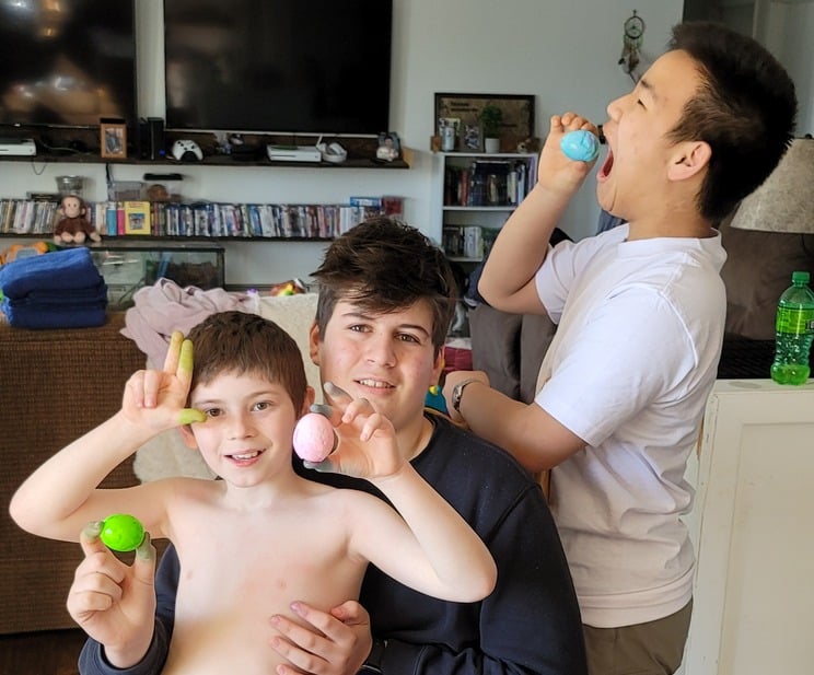 Three boys having posing for picture with easter eggs