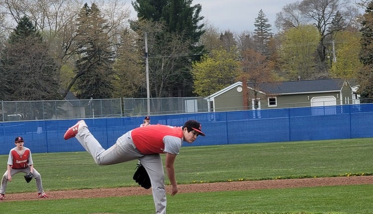 Teenage boy pitching for baseball game