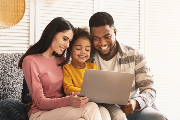 family smiling and looking at computer