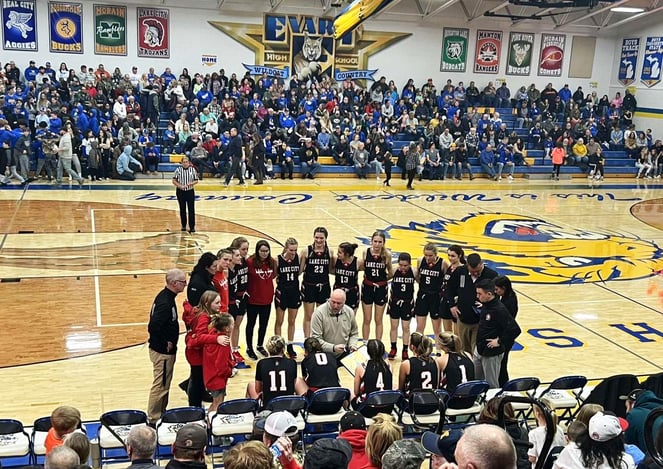 basketball team in circle on court