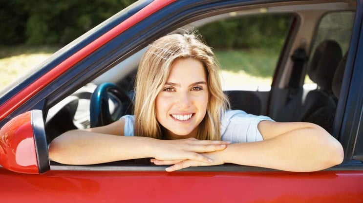 American teenage girl driving red car