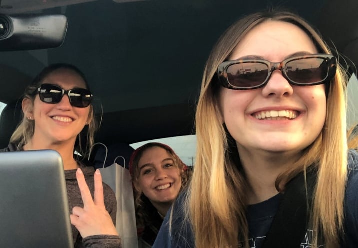 mom and two teen girls in car
