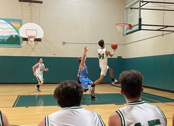 boy making lay-up in basketball game