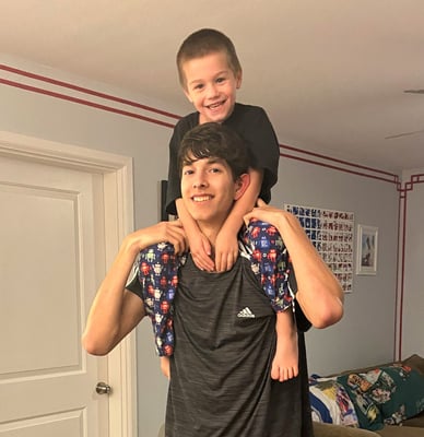 little boy on teen brother's shoulders