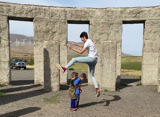 teen boy jumping over 2 little boys