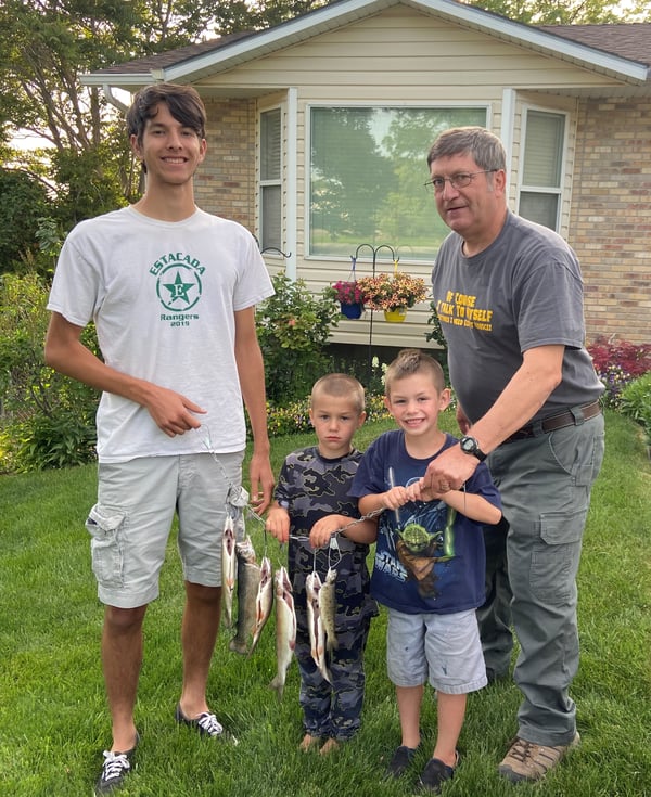 dad, teen and 2 little boys hold string of fish