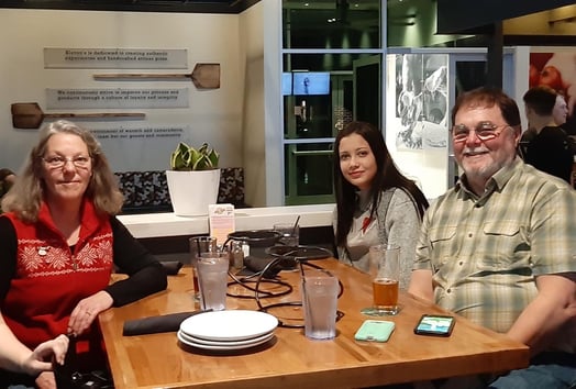 Brazilian exchange student in restaurant with host parents