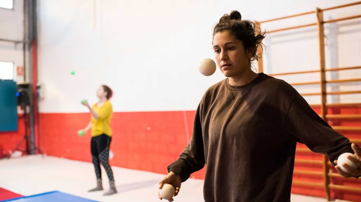 A teenage girl learning how to juggle