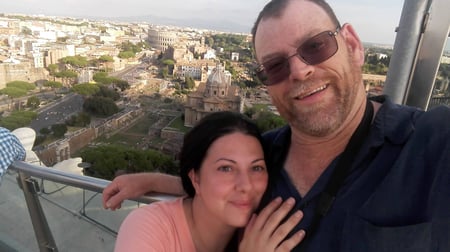 Selfie of Bob & Carla in Rome with the Colosseum behind