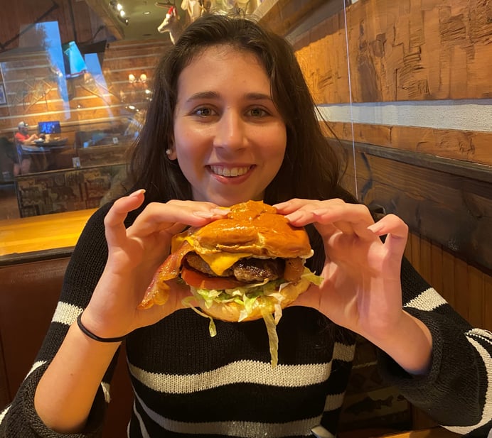 girl eating big, juicy cheeseburger