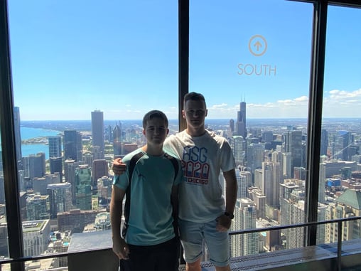 boys in front of large window with Chicago skyline behind