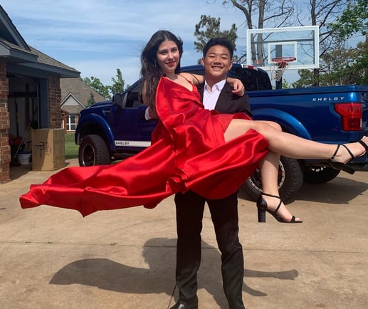 Chihok in a tux holding date in a flowing red dress