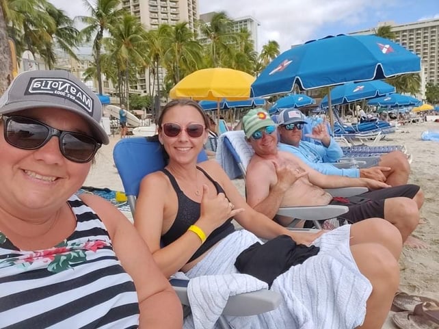 four people in chairs on the beach