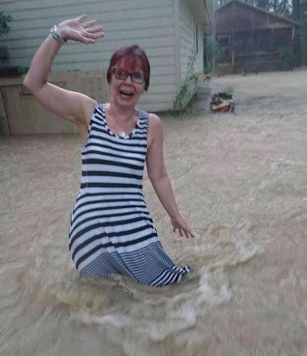 woman standing in flood waters in a dress