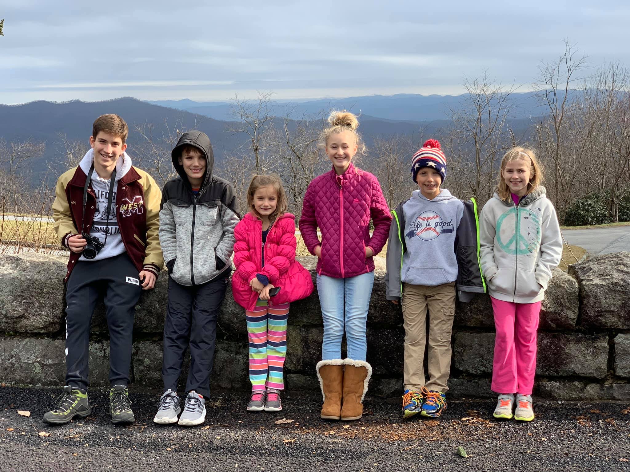 exchange student and five kids with mountain background