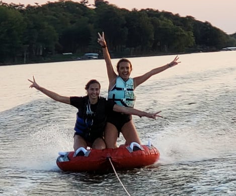 two teens tubing on a lake
