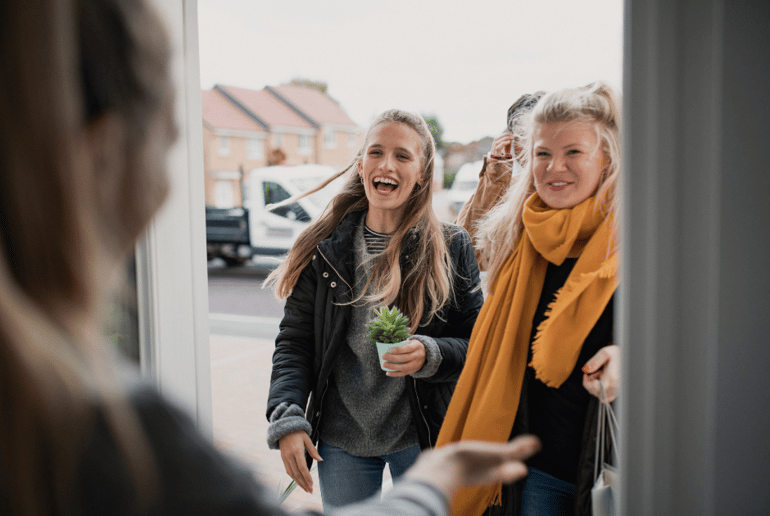 women at the door of a home