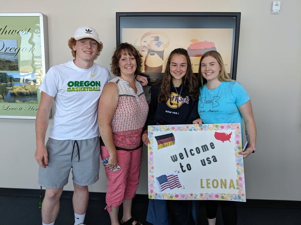 mom and teens greet exchange student