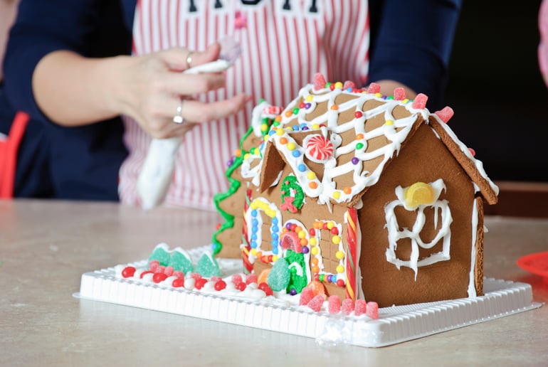 Person decorating gingerbread house