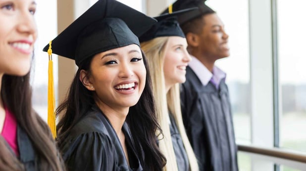 High school senior in cap and gown smiling