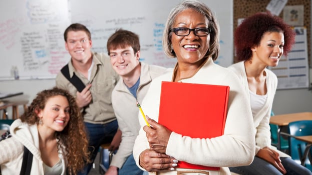 High school students with smiling teacher in class