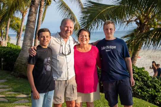 two teen boys with older parents at the beach