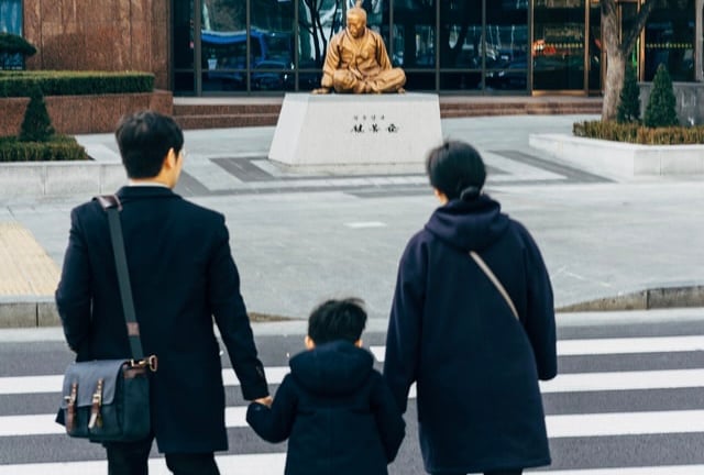 Korean mother, father and small son approaching temple