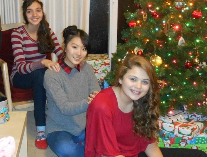 South Korean exchange student with host sisters and Christmas tree