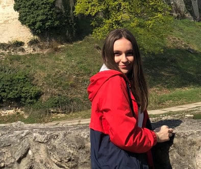 Ivona smiling in front of stone wall