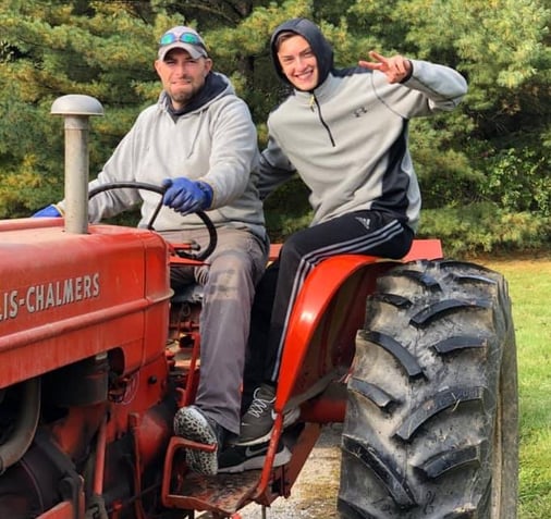 Dad giving teen boy a tractor ride