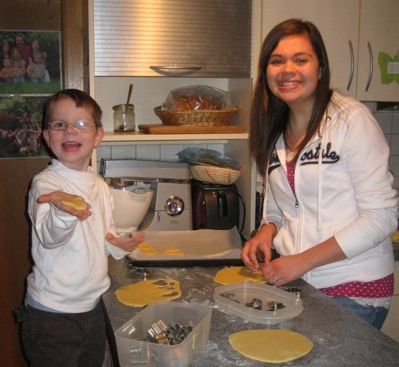 teen girl baking with little boy