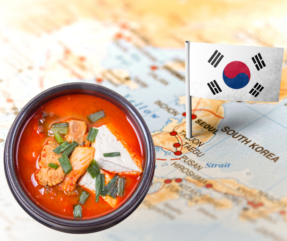 Kimchi Jjigae dish in front of the Korean map and flag.