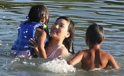 Korean teenage girl playing with little sister and brother in the water