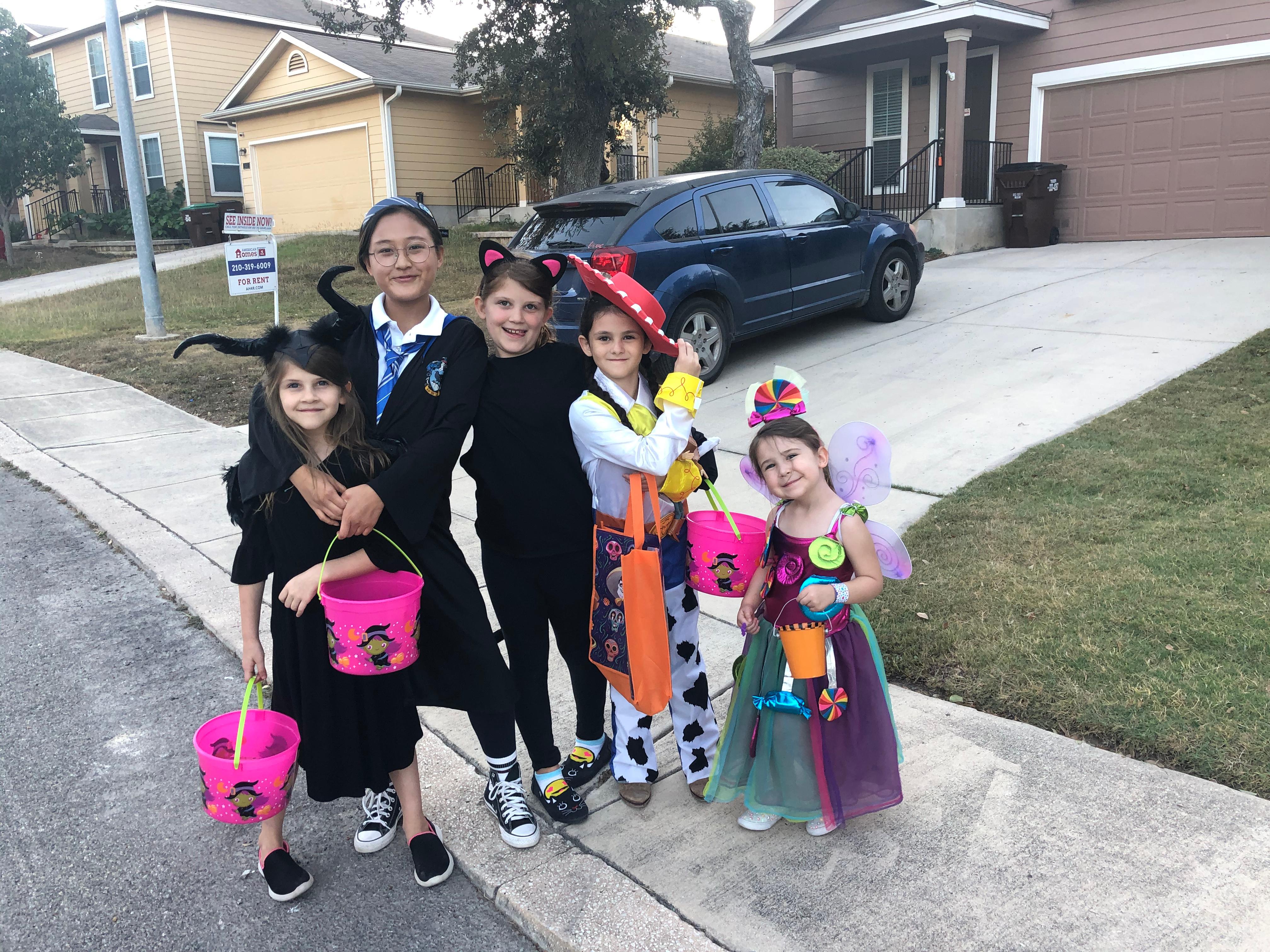 Asian girl with children in costume in front of home