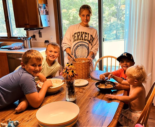 teen girl cooking with four young kids