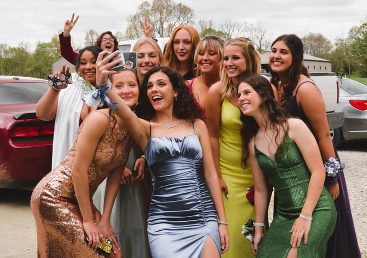 group of girls in formal dresses taking selfie