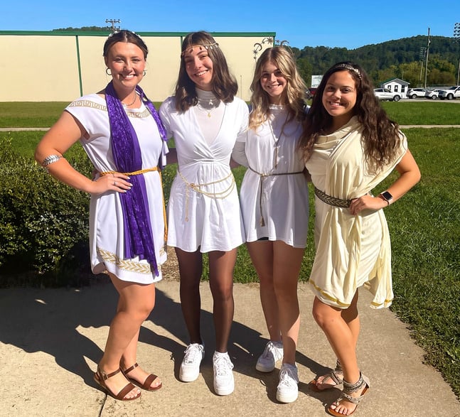 four teen girls dressed in togas