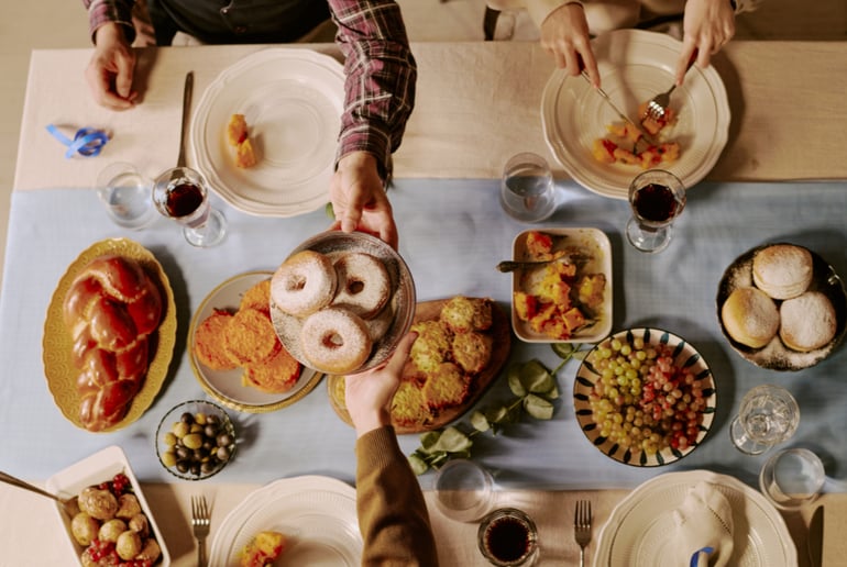 Delicious food on a table with people passing dishes