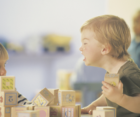 angry toddler holding block