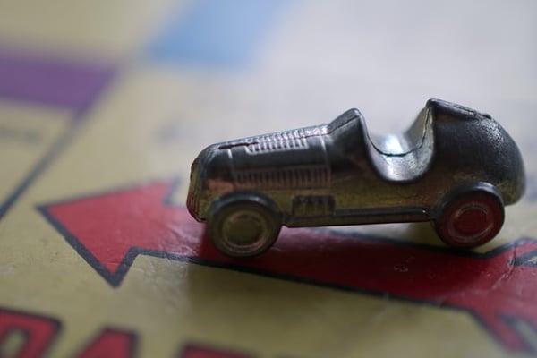 Metal car token on the arrow of a Monopoly board