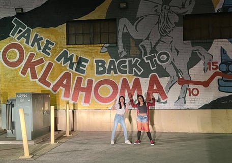 Girls in front of Oklahoma mural