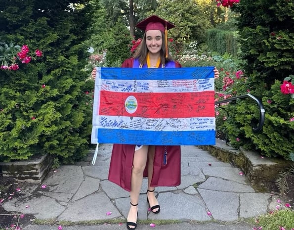 girl in cap and gown holding Costa Rica flag