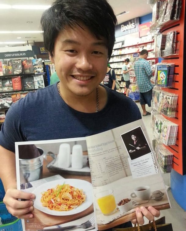 young man holding magazine with food picture