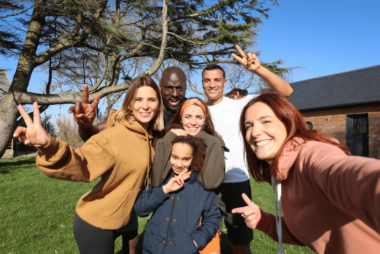 Photo of a diverse family throwing up peace signs and taking a selfie together