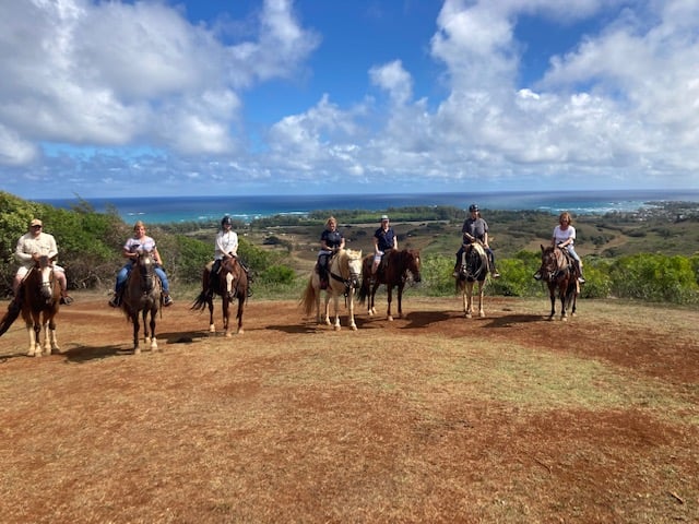 group riding horses in front of ocean