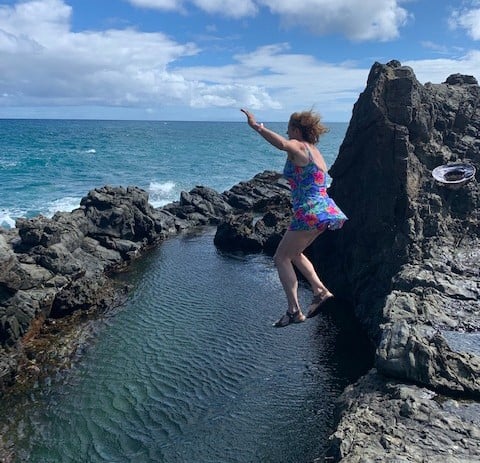 woman jumping into Hawaii swim hole