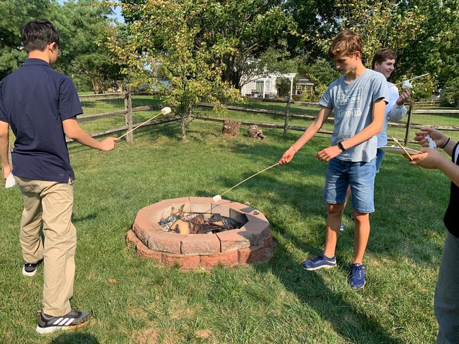teen boys roasting marshmallows