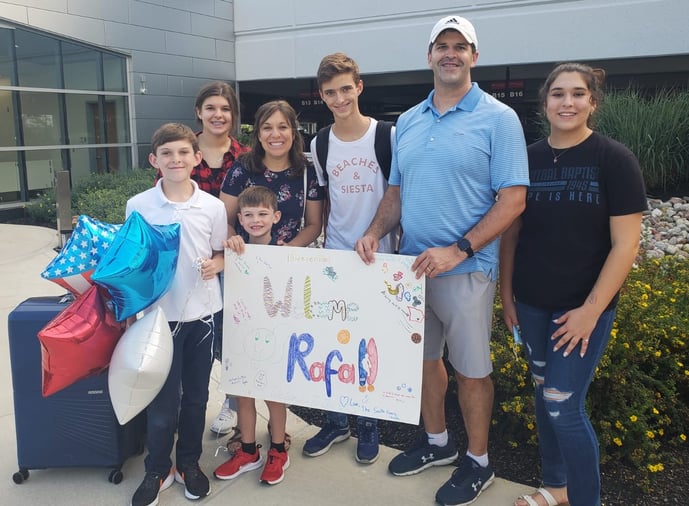 family and exchange student with welcome sign