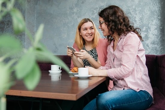 two girls having coffee and talking